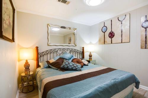 Schlafzimmer mit einem Bett und einem Wandspiegel in der Unterkunft Doyline Cottage with Large Porch and Lake Access! 