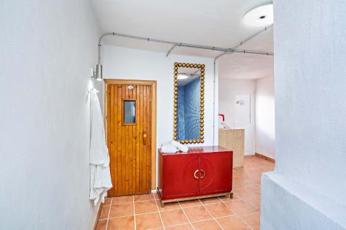 baño con armario rojo y espejo en Apartamentos Dulcemar Frente al Mar con zona SPA, en San José