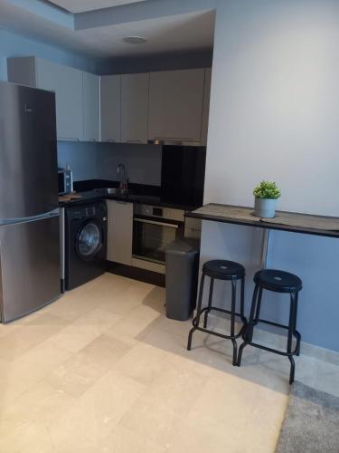a kitchen with a counter and two bar stools at Studio luxury casablanca in Casablanca