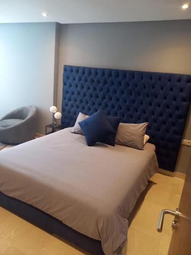 a large bed with a blue padded headboard in a bedroom at Studio luxury casablanca in Casablanca