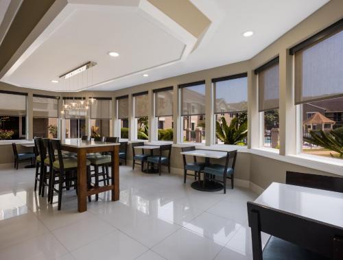 a dining room with tables and chairs and windows at Sleep Inn Savannah Midtown in Savannah