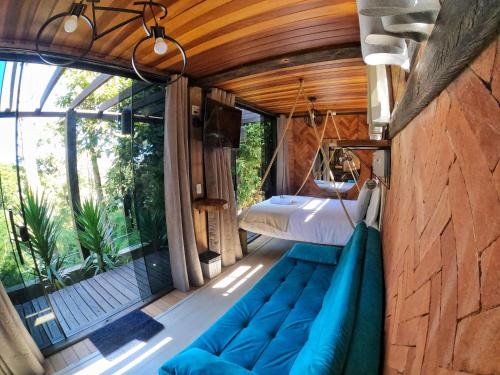 a room with a couch and a bed and a window at Casa Container 80 in Campos do Jordão