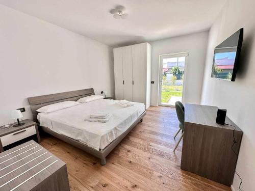 Schlafzimmer mit einem Bett, einem Schreibtisch und einem Fenster in der Unterkunft Casa del Sol Luxury Estate Puglia in Leporano Marina