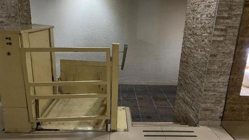 a wooden chair sitting in the corner of a room at Rosales.RM - Depto completo 2 ambientes con patio. in Ramos Mejía