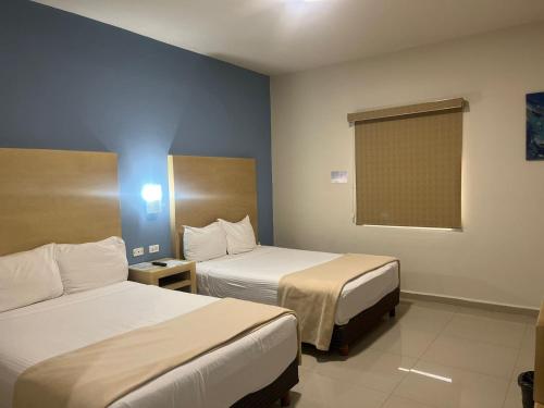 a hotel room with two beds and a window at Capital Hotel in Monclova