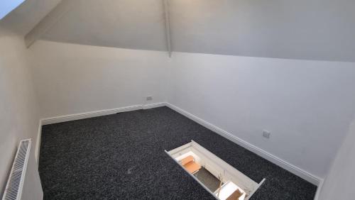 een lege kamer met een witte muur en een lege vloer bij En Suite room with kitchen facilities in Nottingham