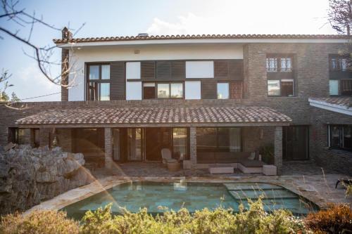 a house with a swimming pool in front of it at Es Cloper in Cadaqués