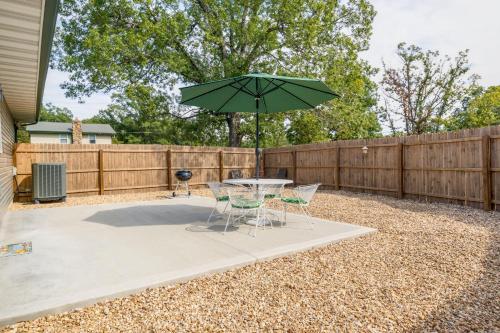 a patio with a table and chairs and an umbrella at Charming Gravois Mills Escape with Private Backyard! in Gravois Mills