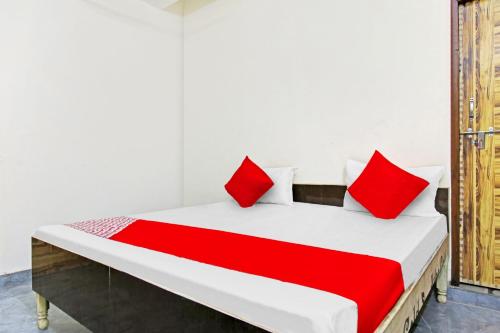 ein Schlafzimmer mit einem großen Bett mit roten Kissen in der Unterkunft OYO Flagship Skyway Residency in Indraprast