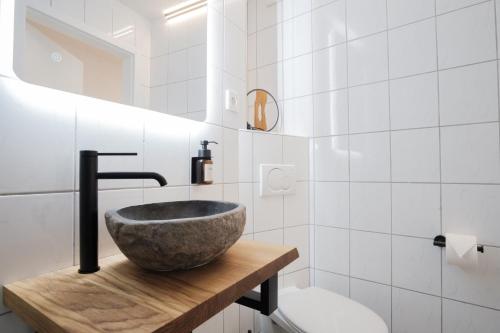 a bathroom with a stone sink on a wooden counter at NEU / Design / Altstadt / Küche / NETFLIX in Bad Säckingen