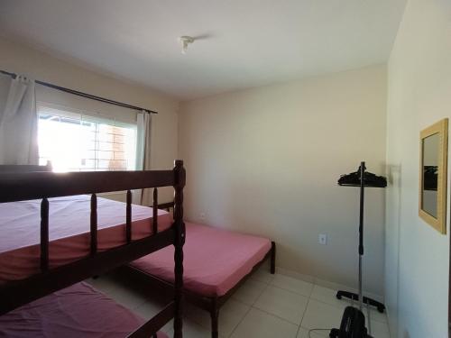 a bedroom with a bunk bed and a window at Excelente casa na praia em Matinhos PR. 600 metros da praia. in Matinhos