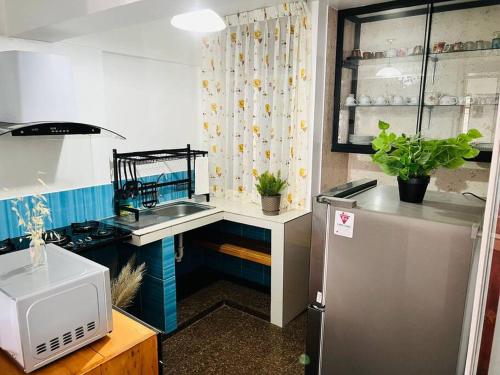 a small kitchen with a sink and a refrigerator at Qouyllur House in Marcará