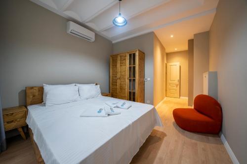 um quarto com uma cama branca e uma cadeira vermelha em Historic 1 Bedroom Galata Apt-Heart of Istanbul Kuledibi 2 em Istambul