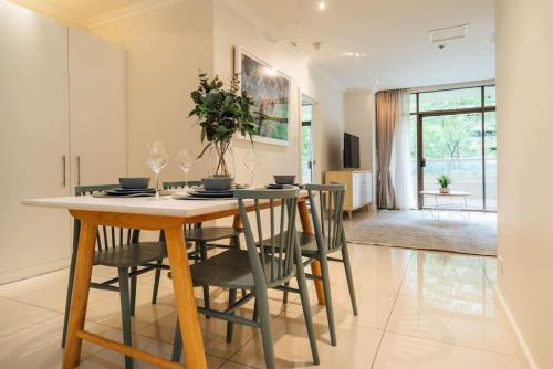 a kitchen and dining room with a table and chairs at Serene on Grenfell Adelaide in Adelaide