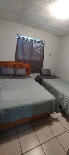 a bedroom with two beds and a window at Depa M&J Cd. Juarez in Ciudad Juárez