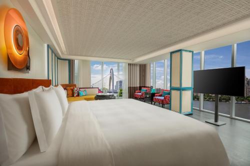 a hotel room with a large bed and a flat screen tv at Hotel Indigo Guangzhou Haixinsha by IHG - Free Shuttle Bus to Canton Fair Complex during Canton Fair period in Guangzhou
