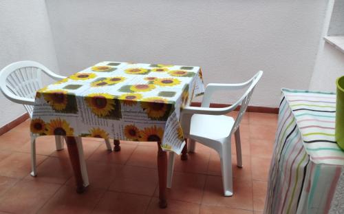 una mesa con dos sillas y un mantel con flores. en Ancora en Deltebre