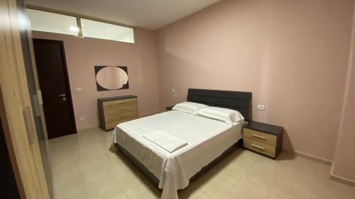 a bedroom with a large bed and a mirror at Anna´s apartament in Lushnjë