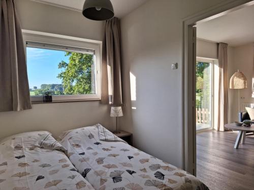 um quarto com uma cama, uma janela e uma mesa em Domein Hellebeuk met UITZICHT! Valkenburg/Klimmen em Klimmen