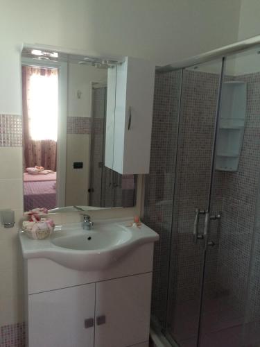 a bathroom with a sink and a glass shower at B&B Giorgio La Pira in Santa Maria del Focallo
