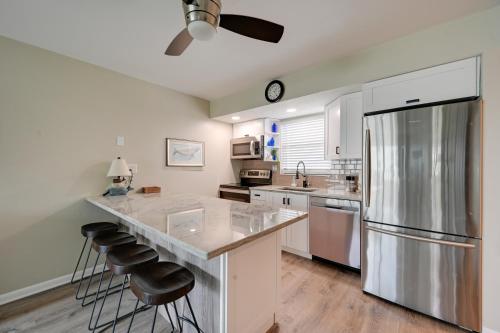 a kitchen with a large island with bar stools at Waterfront Marco Island Condo with Pool and Hot Tub! in Marco Island