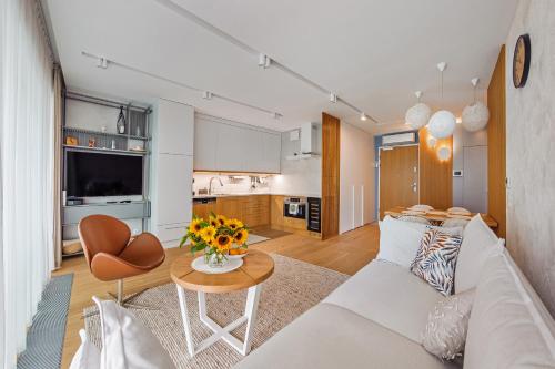 a living room with a white couch and a table at Little Monaco - Yacht Park in Gdynia