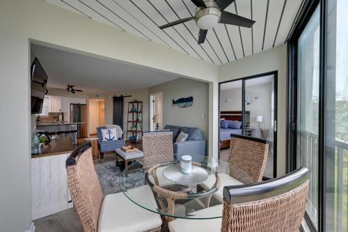 a dining room and living room with a table and chairs at Waterfront Marco Island Condo with Pool and Hot Tub! in Marco Island