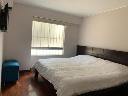 Un dormitorio con una cama grande y una ventana. en MLA apartments - Bolognesi, en Lima