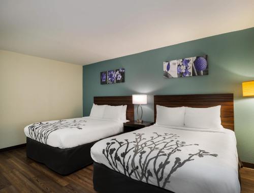 a hotel room with two beds and two lamps at Sleep Inn Savannah Midtown in Savannah