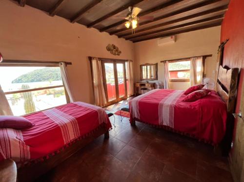 1 dormitorio con 2 camas y ventana grande en Casa Concepcion Suites, en Punta Arena