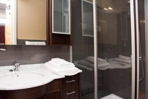 La salle de bains est pourvue d'un lavabo et d'une douche. dans l'établissement Precioso apartamento en primera línea de playa, à Palamós