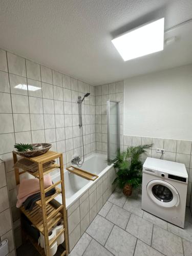 een badkamer met een bad en een wasmachine bij Naumburger Charme "Goldener Steiger" in Naumburg