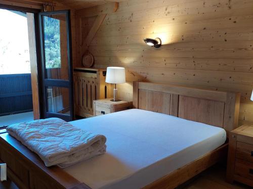 een slaapkamer met een bed in een houten hut bij Appartement Chamonix-Mont-Blanc, 3 pièces, 6 personnes - FR-1-517-15 in Chamonix-Mont-Blanc