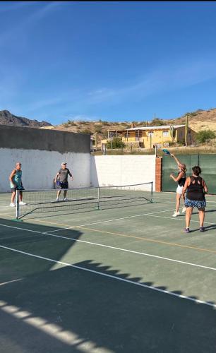 a group of people playing tennis on a tennis court at Playa Posada Eco Rooms in Punta Arena