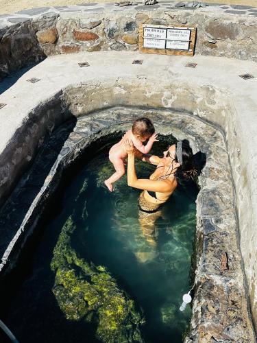 a woman and a child in a pool of water at Playa Posada Eco Rooms in Punta Arena