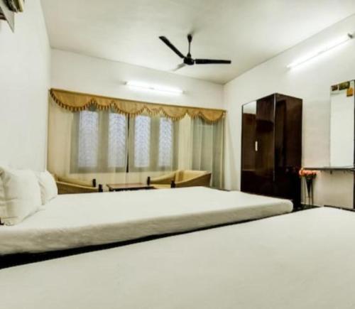 a bedroom with a large bed with a ceiling fan at Hotel Natraj in Rānchī