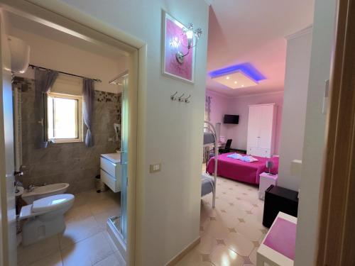 ein Bad mit einem Waschbecken und einem WC sowie ein Schlafzimmer in der Unterkunft B&B Afrodite in Leporano