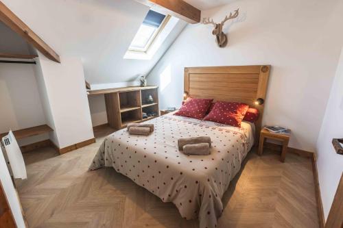 een slaapkamer met een bed met een houten hoofdeinde bij Le Rioumajou 2 in Saint-Lary-Soulan