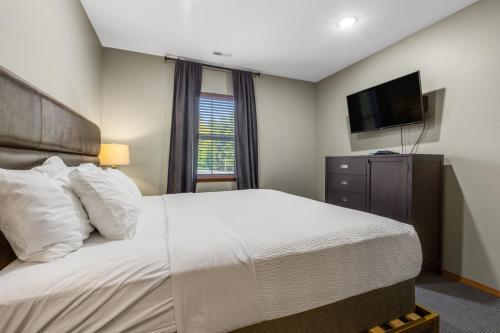 a bedroom with a large bed and a flat screen tv at Tumwater Vista Retreat, Unit 903 in Leavenworth