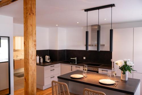 a kitchen with white cabinets and a black counter top at Exklusives Apartment in bester Lage in TBB in Tauberbischofsheim