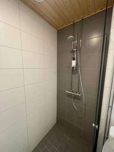 a shower with a glass door in a bathroom at Location courte durée, jolie appartement lumineux in Vantaa