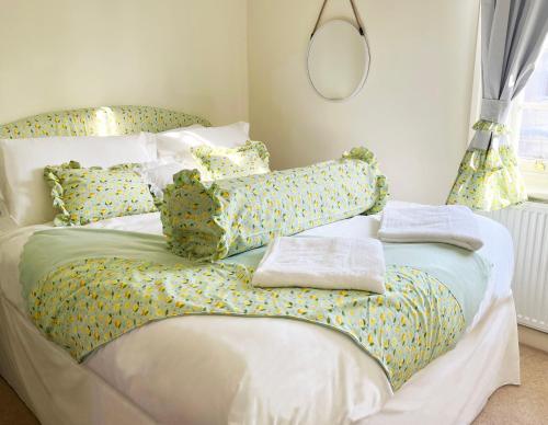 una cama blanca con almohadas y un cactus en ella en Traditional 2 bedroom Cottage, en Stratford-upon-Avon