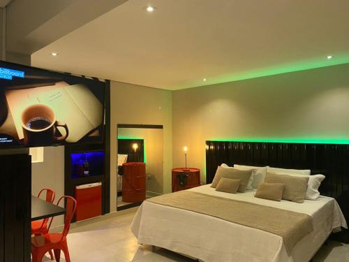 a bedroom with a large bed with a green lighting at KANKUN MOTEL E POUSADA -Adult only in Sorocaba