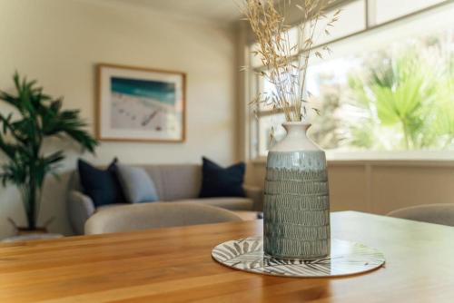a vase sitting on a plate on a table at Beachy Keen on Moseley in Glenelg