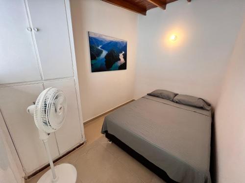 um pequeno quarto com uma cama e uma ventoinha em Sereni Laureles Hotel Cafe em Medellín