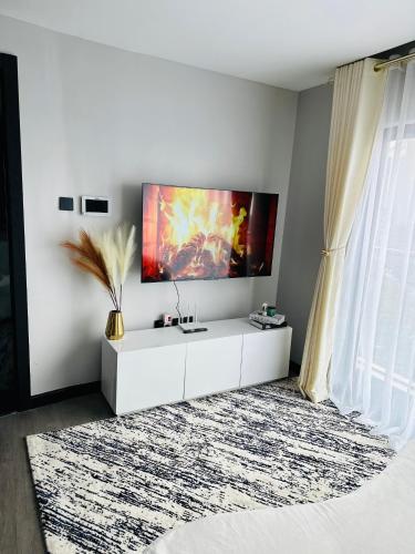 a white living room with a tv on the wall at Escada in Nairobi