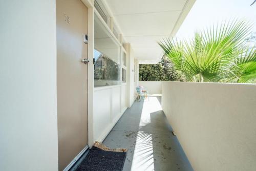 a hallway of a house with a door and plants at Beachy Keen on Moseley in Glenelg
