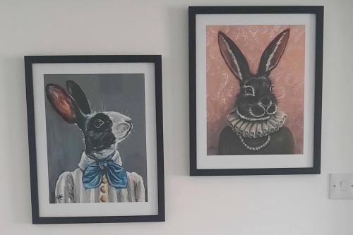 dos cuadros enmarcados de un perro y un conejo en una pared en Phoenix House 4 BED ideal contractor & those working away, en Lincolnshire
