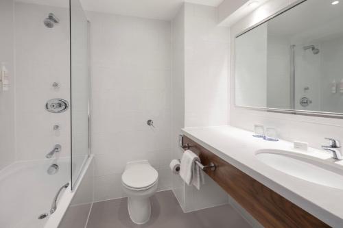 Delta Hotels by Marriott Swansea في سوانسي: حمام مع حوض ومرحاض ومرآة