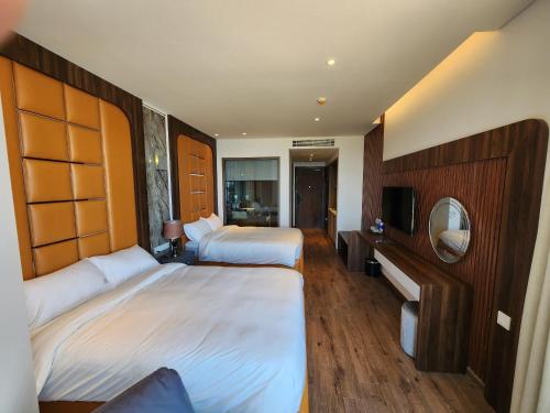 a hotel room with two beds and a mirror at Apec Mandala Mui Ne 2124 in Phan Thiet